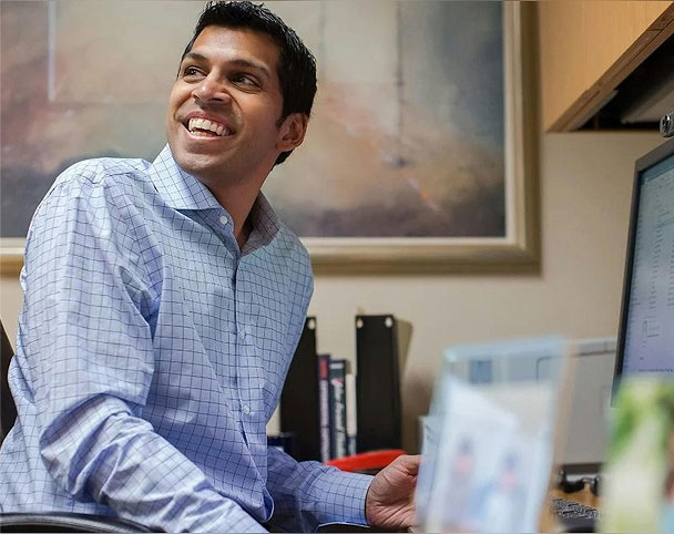 Ronnie Chatterji turning away from a computer smiling