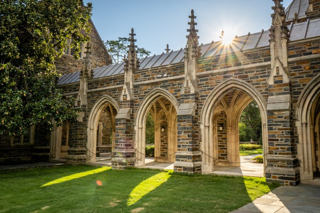 The roof of a gothic architecture building with arch walkways and pointed stone pillars.