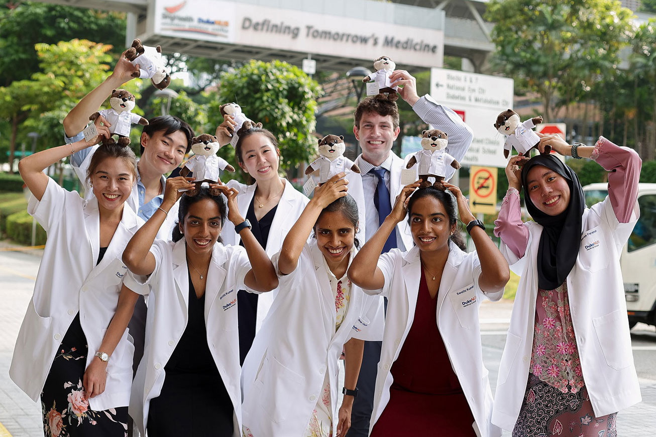 Duke NUS students pose for a photo outside with stuffed animals on their heads